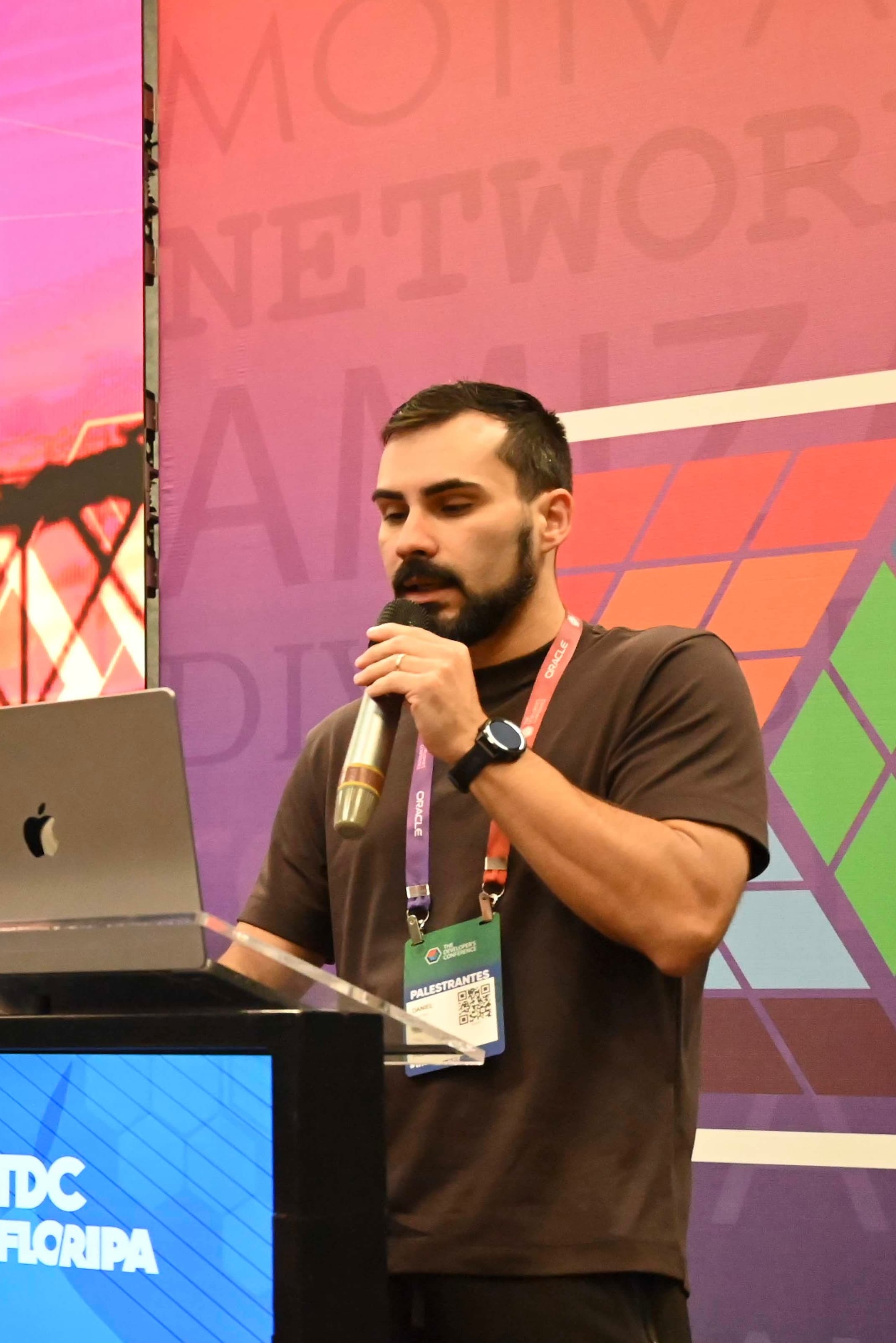 Daniel Castro palestrando no palco do TDC Floripa em 2026, com microfone